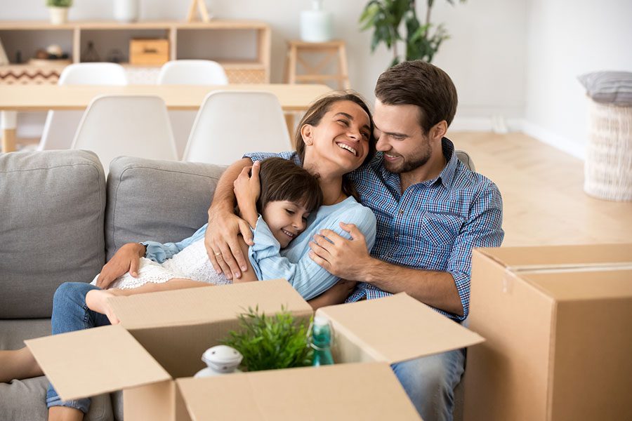 Personal Insurance - Happy Family Sitting on the Couch Enjoing Their New Home